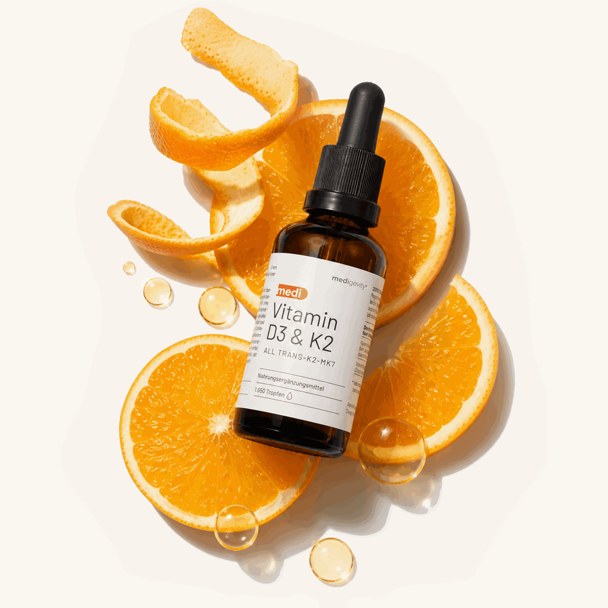 medi Vitamin D3 & K2 Tropfen (1.650 Tropfen, All Trans-K2-MK7) auf Orangenscheiben mit Öltropfen